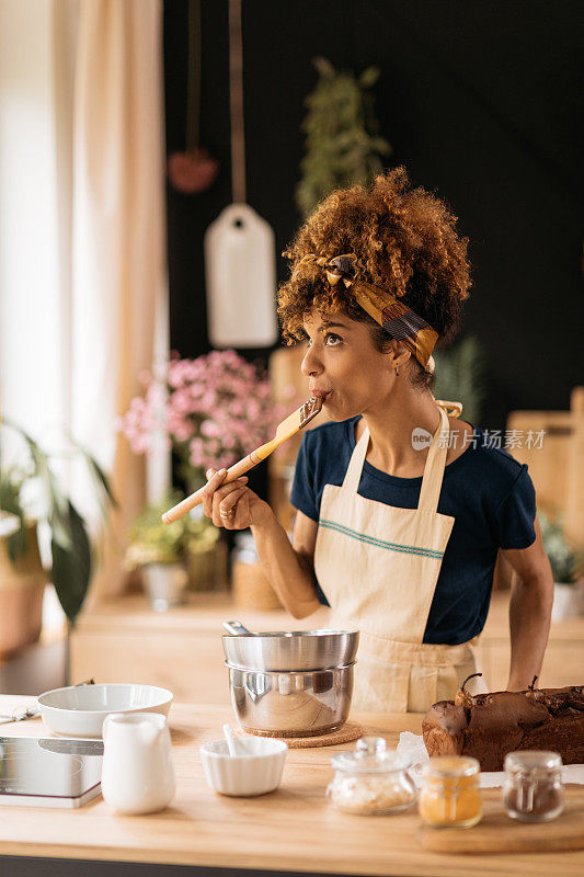 Attractive young African American woman experimenting in her kitchen